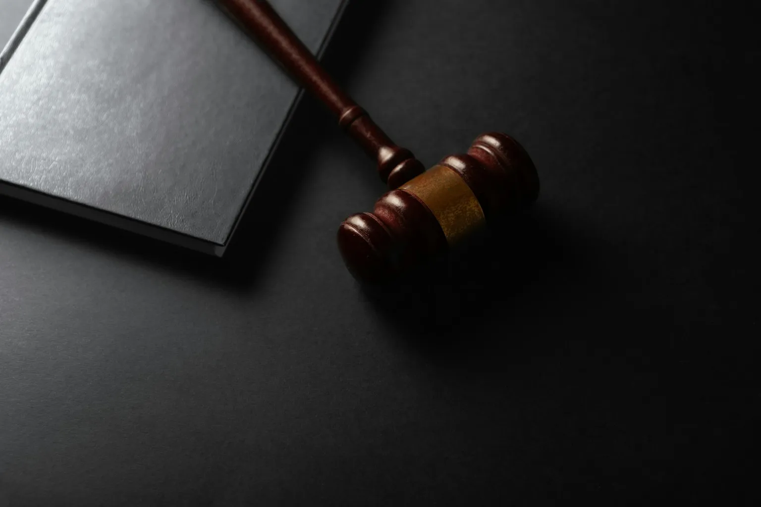 A judge's gavel resting on a closed book